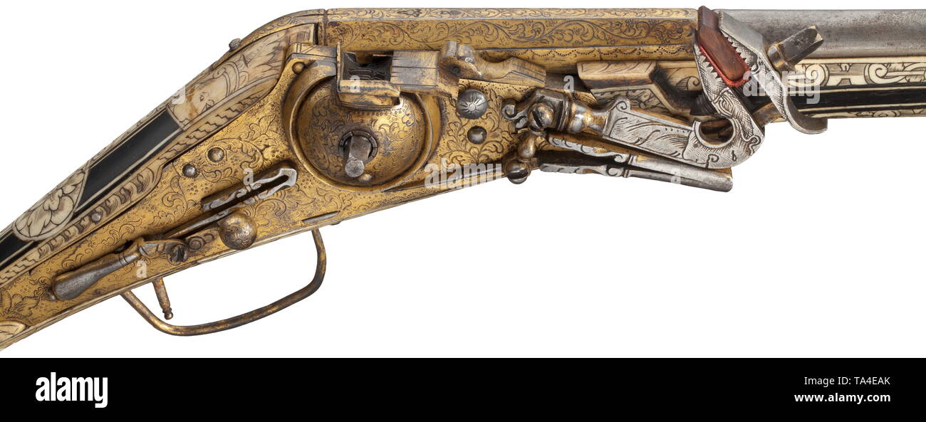 A bone-inlaid, gilt wheellock puffer, Augsburg, circa 1580/90 Two-stage barrel, octagonal breech section, then round after cut girdles, with smooth bore in 13 mm calibre. Over the muzzle and chamber florally engraved, gilt decoration. The top of the barrel with two struck Augsburg marks, Pyr and flower within a shield. Gilt and chiselled wheellock en suite engraved with flowers, with domed wheel cover and spring-loaded safety lever. Ebonised fruitwood stock with engraved and blackened, profuse bone inlays. The pommel with stripe and disc inlays i, Additional-Rights-Clearance-Info-Not-Available Stock Photo