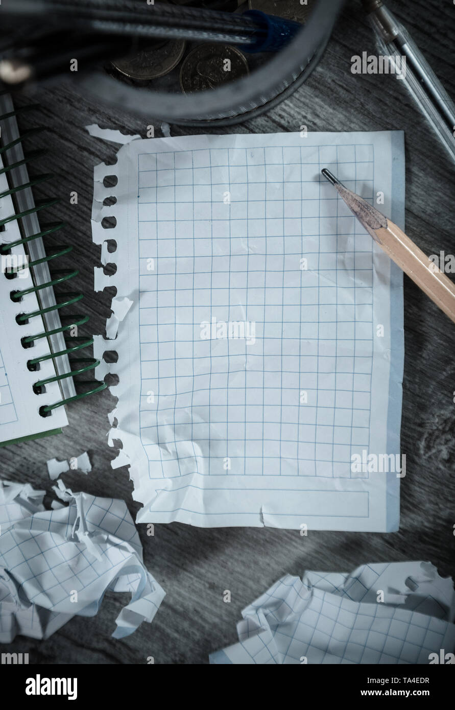 Crumpled empty pages and notebook lying on wooden surface Stock Photo