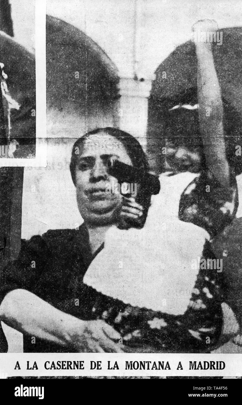 Photo of a mother with her daughter on her arm in the streets of Madrid after the outbreak of the Spanish Civil War in the summer of 1936. The daughter raises her fist and holds a pistol in her hand. The photo was printed in Spanish national newspapers. Stock Photo