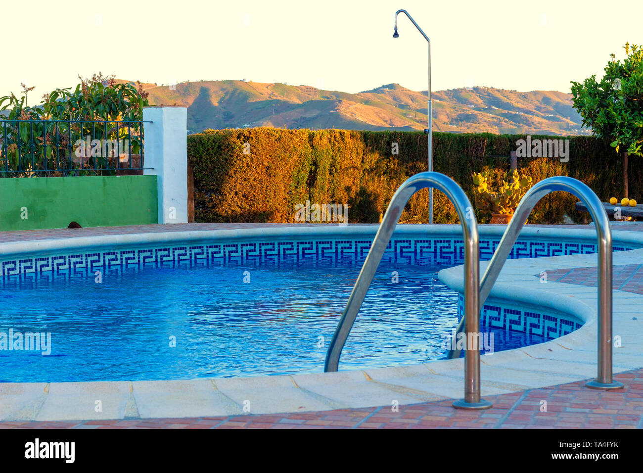 A luxury swimming pool set in an idyllic landscape surrounded by countryside and mountains in Malaga, Spain Stock Photo