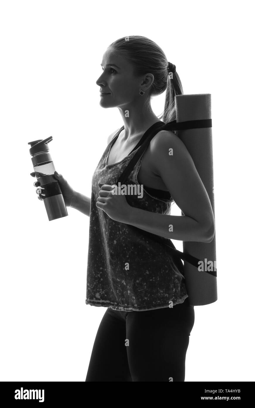 Portrait of sporty woman with yoga mat and bottle of water on white ...