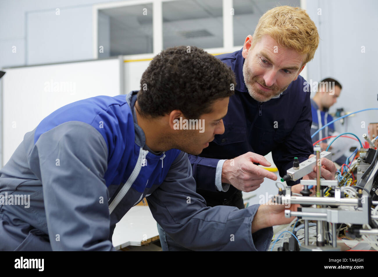 two technicians working on a machine in factory Stock Photo