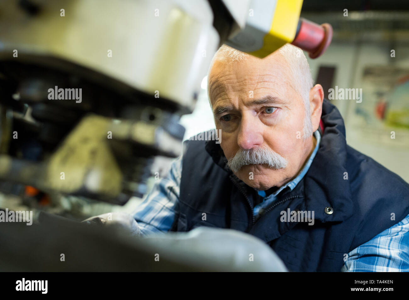 senior worker using a machine Stock Photo