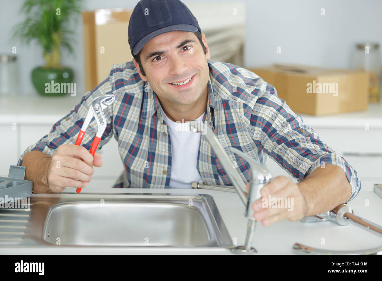 plumber assembling sink pipes Stock Photo