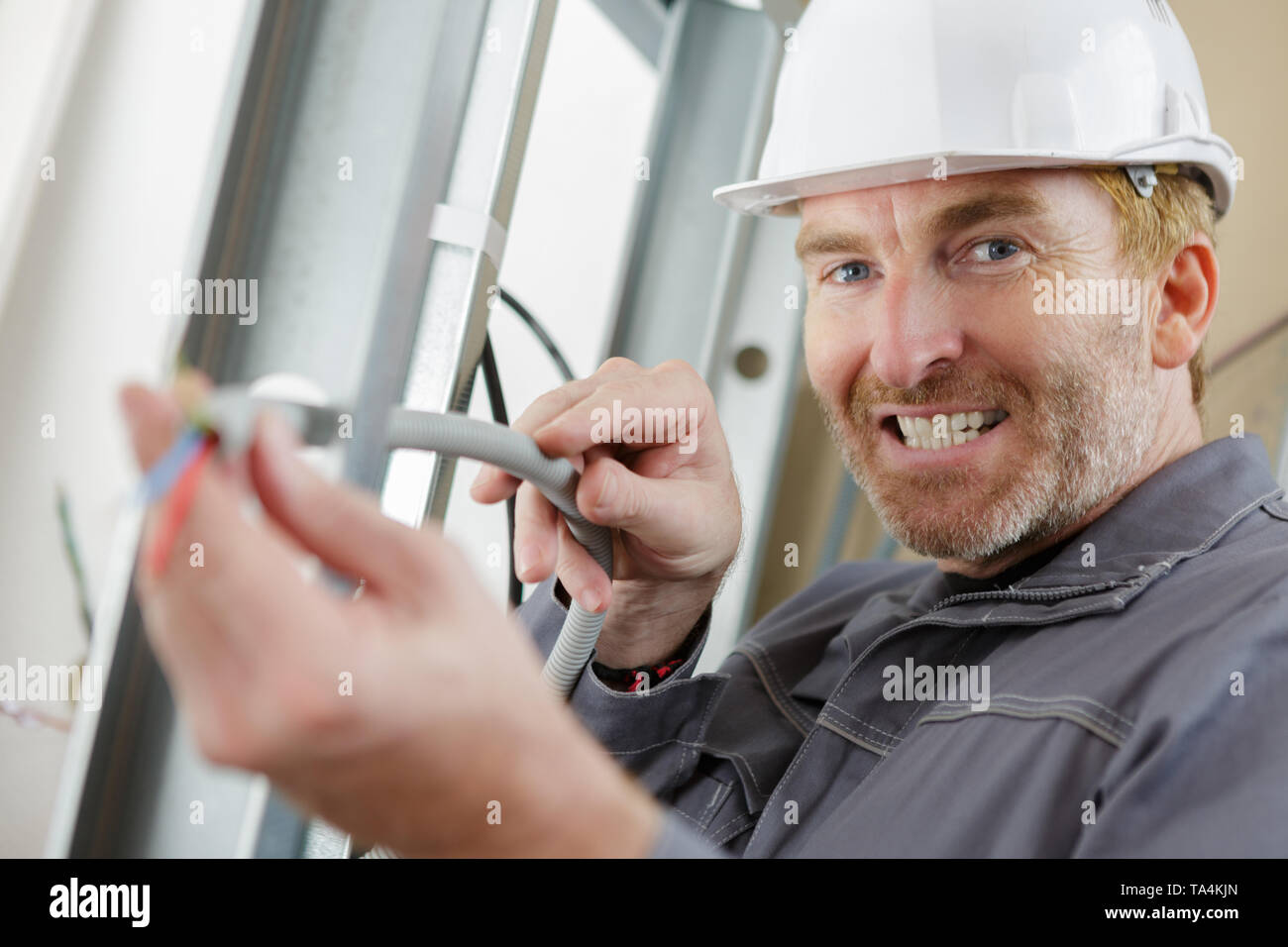 electrician drilling hole on metal for routing Stock Photo Alamy
