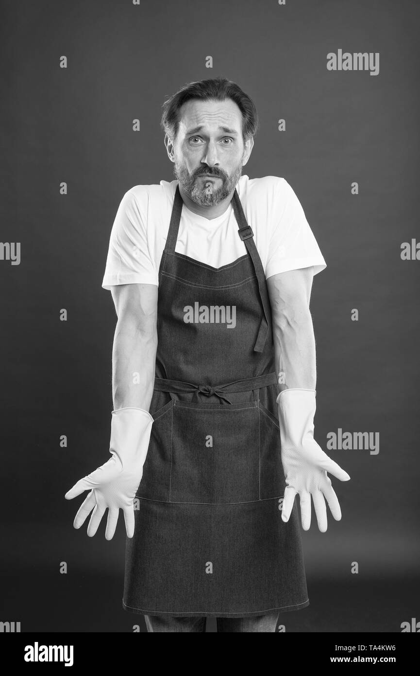 Cleaning service and household duty. Lot of work. Gardening concept. Man in apron with gloves cleaning agent. Cleaning day today. Bearded guy cleaning home. On guard of cleanliness and order. Stock Photo