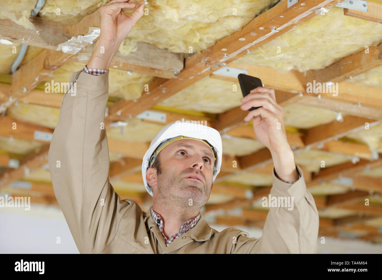 male builder taking pictures indoors Stock Photo