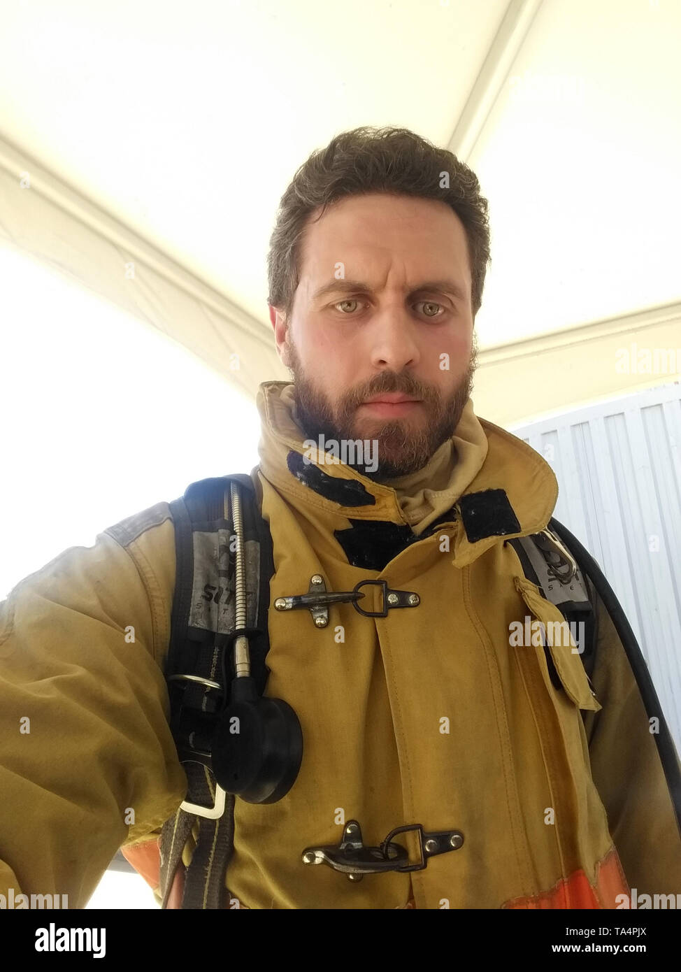 On guard. Firefighter with uniform taking selfie. Masculinity and male