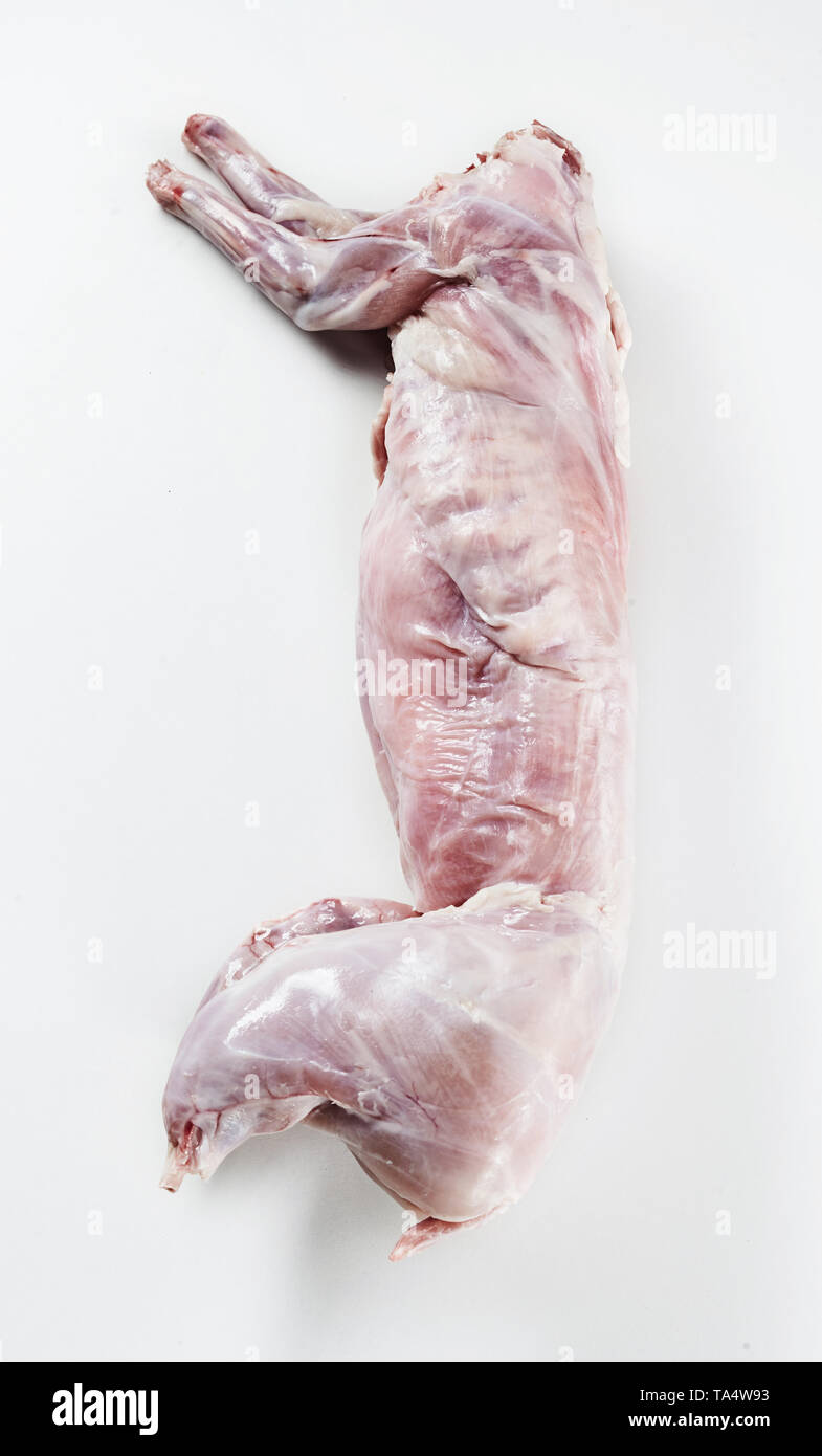 Cleaned skinned wild rabbit carcass ready for roasting lying on a white background viewed from above in vertical format Stock Photo