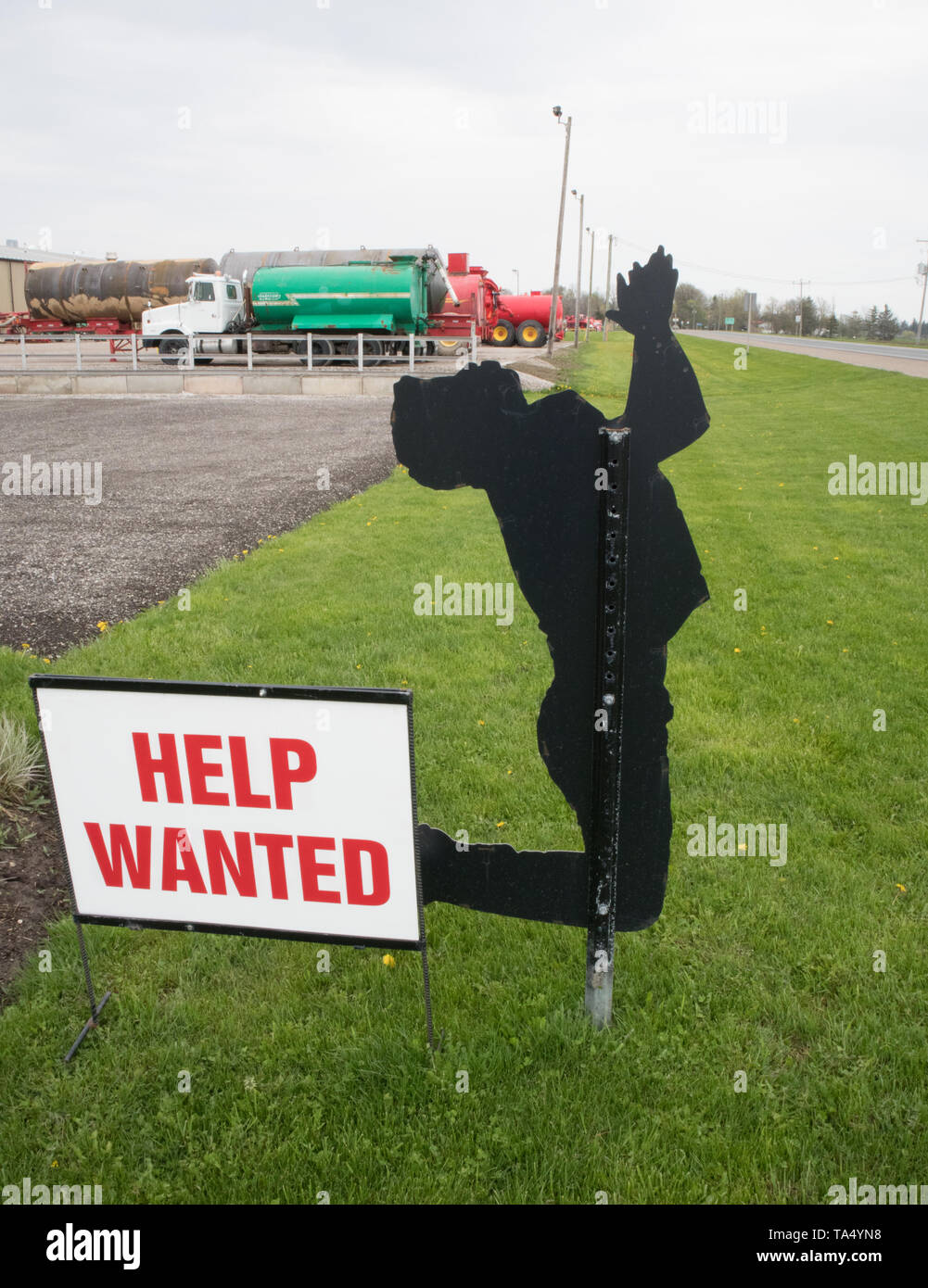 Countryside: an advertisement asking for HELP. This ad is represented by a metal figure who prays to God! Stock Photo