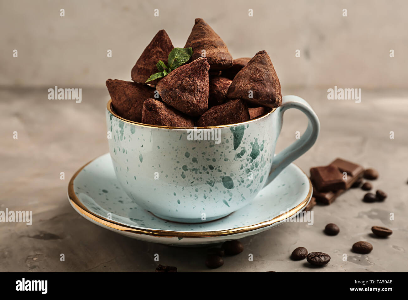 Cup with tasty sweet truffles on grey table Stock Photo