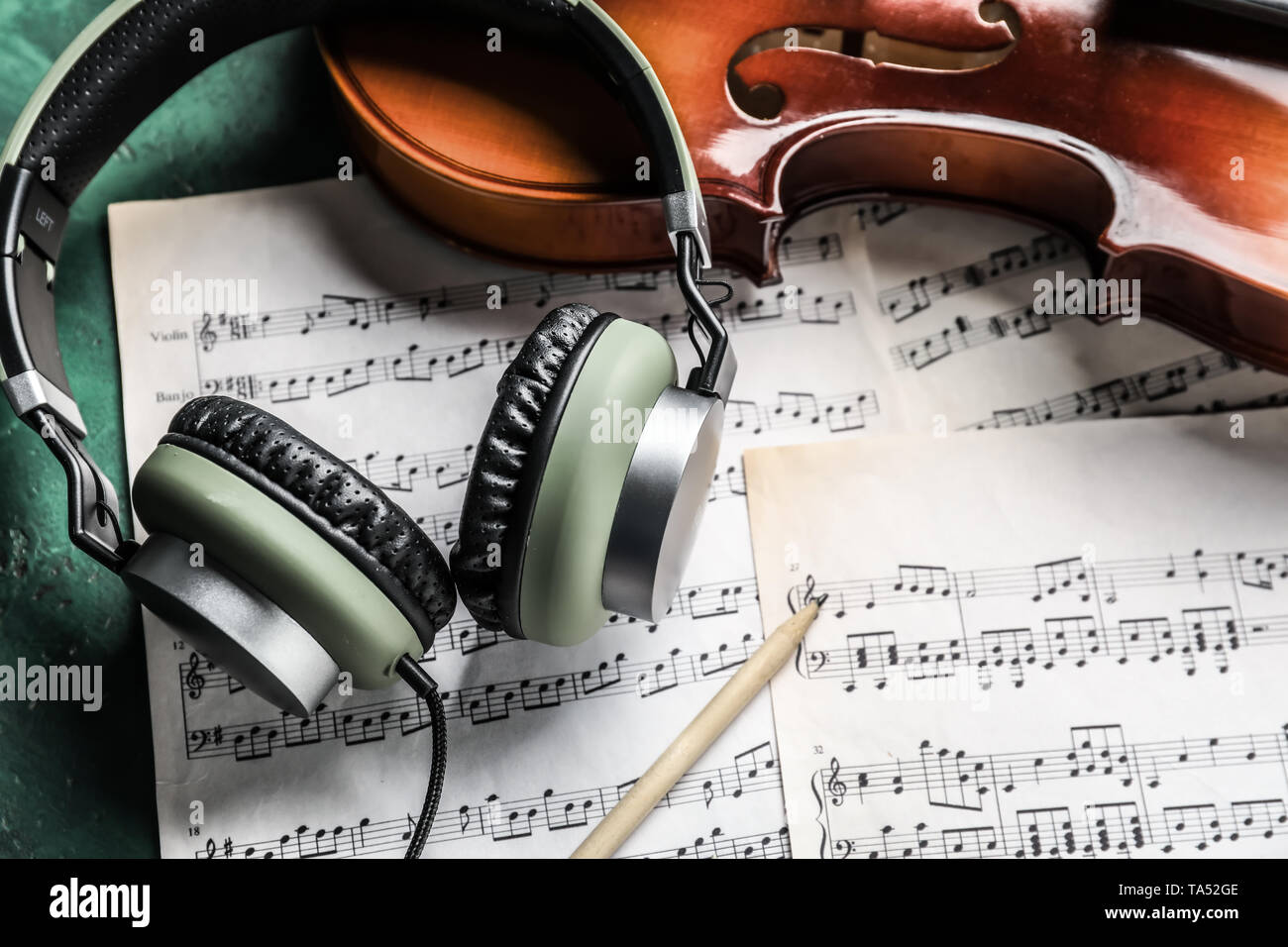 Violin, headphones and music sheets on table Stock Photo - Alamy