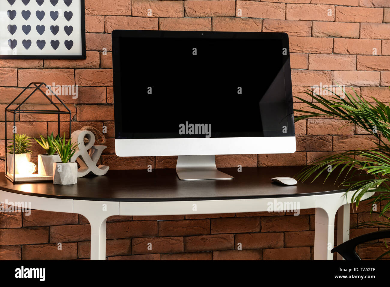 Modern computer on table near brick wall Stock Photo - Alamy