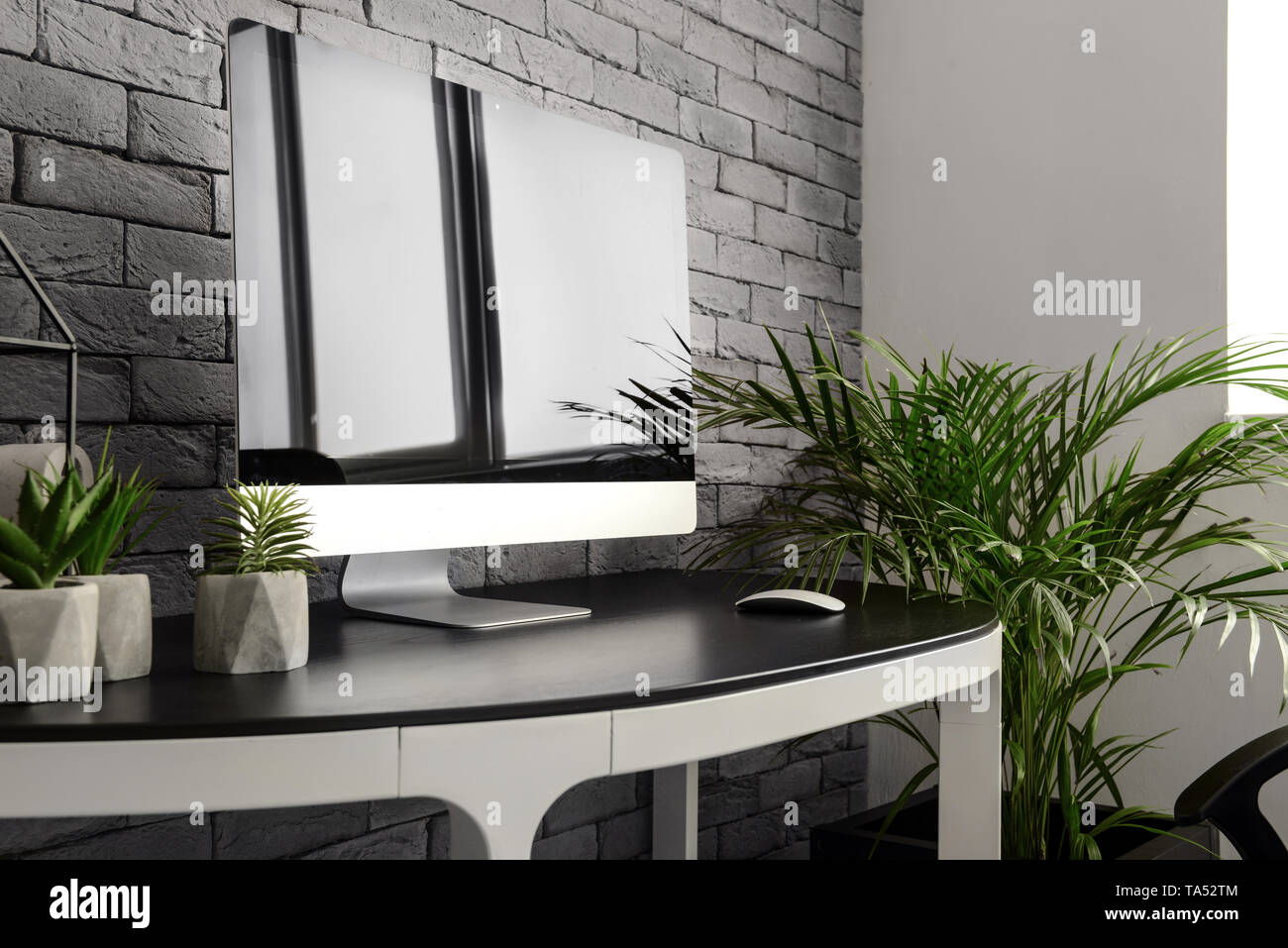 Modern computer on table near brick wall Stock Photo - Alamy