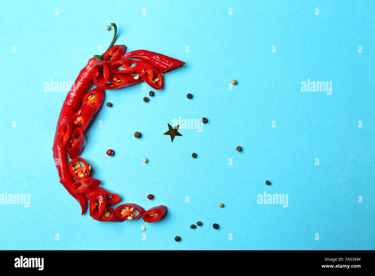 Half-moon made of chili peppers as symbol of Islam on color background ...
