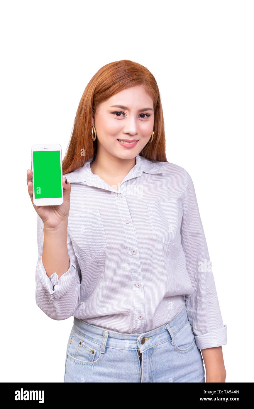 smiling Asian woman holding mobile smartphone with blank green screen standing on white background , clipping path include Stock Photo