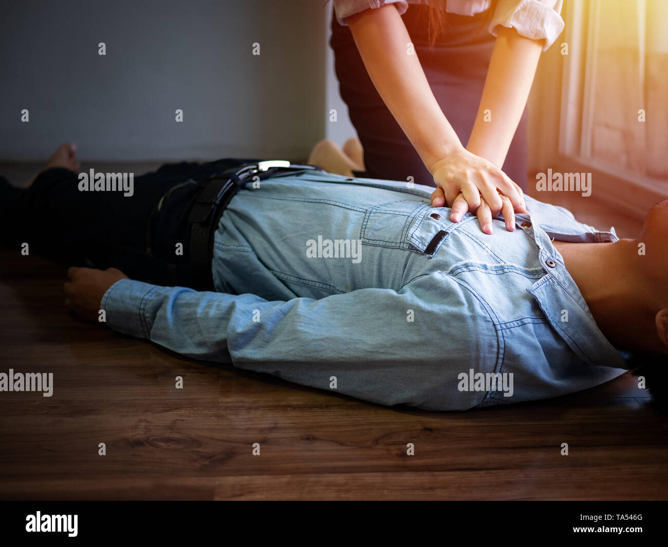 volunteer office woman use hand pump on chest for first aid emergency CPR on heart attack man unconscious, try to resuscitation patient man at work Stock Photo