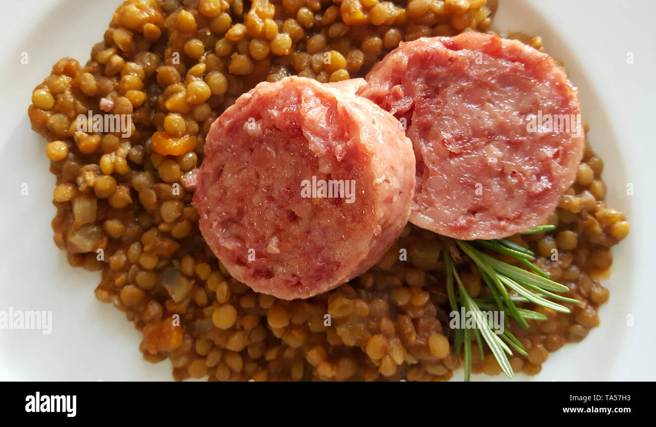 New Year's Eve Meal Italian Style. Top view of two slices of cotechino (pork sausage), lentils