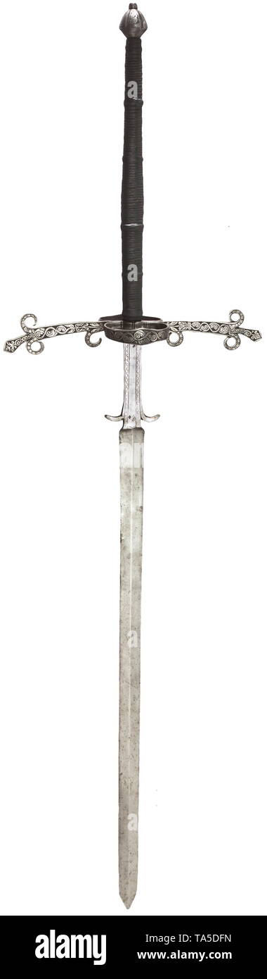 A German two-handed sword, circa 1600 Straight, double-edged blade with slight medial ridge. The long ricasso with split guards and decorated with a pattern of struck waves and lines. Extended quillons with guard rings on each side and cut with decorative tendrils. Replaced grip with cord winding covered in leather. Double tapered pommel with matching chiselled decoration. Length 180 cm. historic, historical, sword, swords, weapons, arms, weapon, arm, fighting device, military, militaria, object, objects, stills, clipping, clippings, cut out, cut, Additional-Rights-Clearance-Info-Not-Available Stock Photo