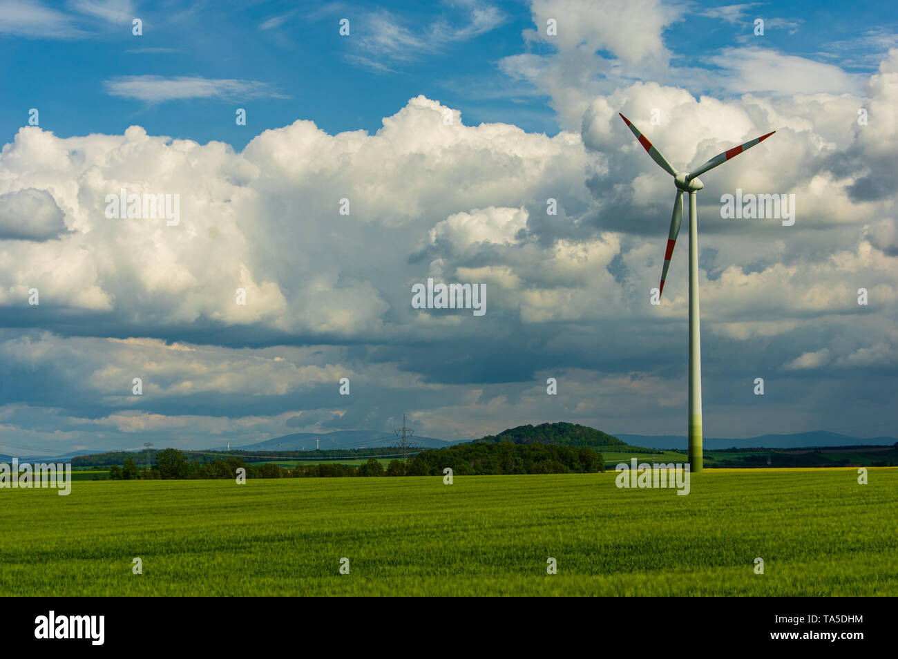 single wind turbine in rural area in front of storm cloud cumulus sky Stock Photo