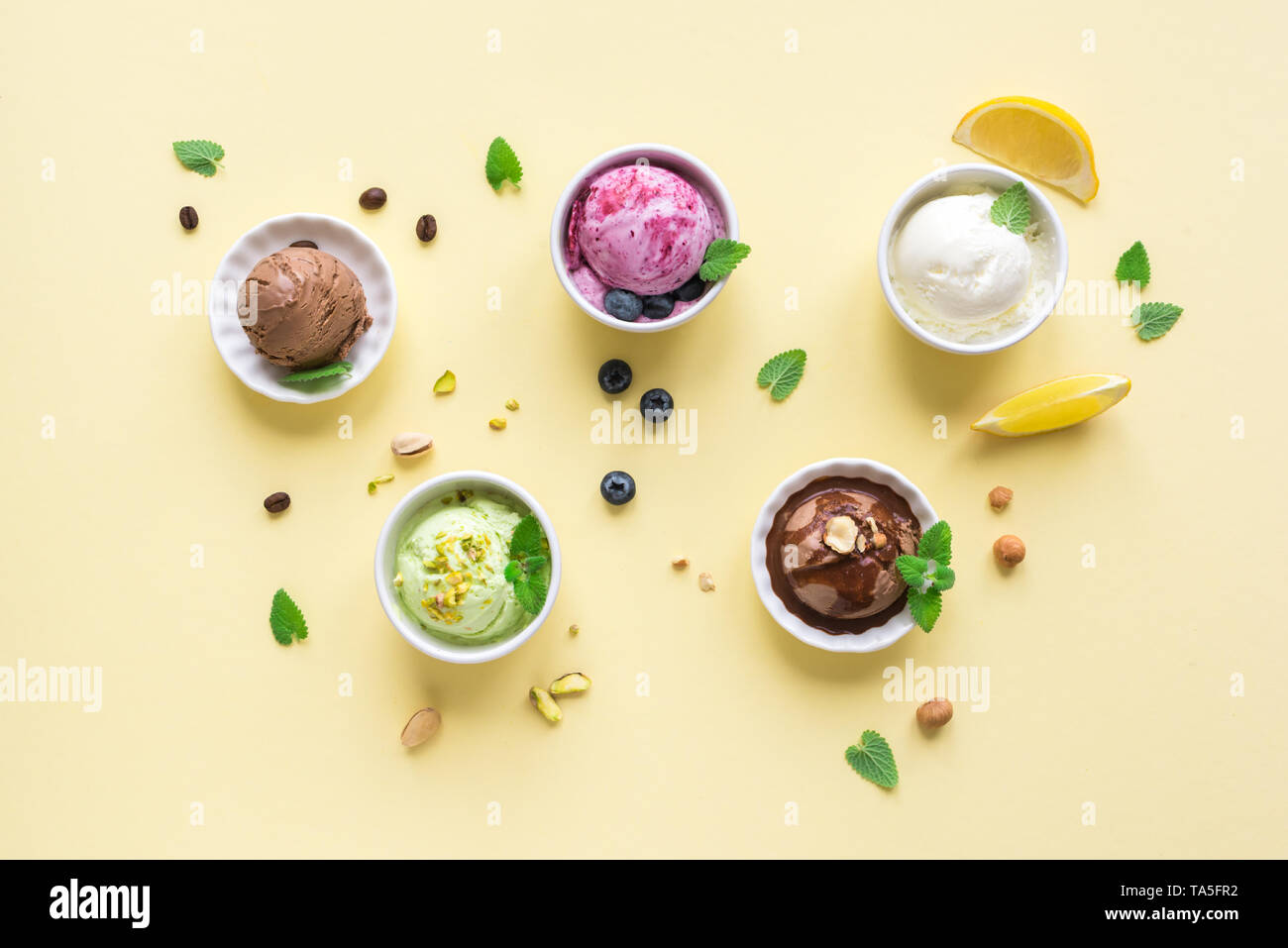 Ice Cream Assortment. Various ice creams in bowls on yellow background