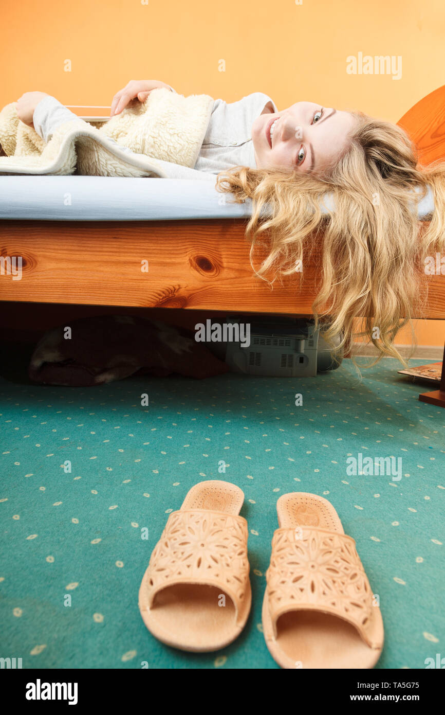 Woman waking up in bed in the morning after sleeping. Young girl laying under wool blanket. Stock Photo