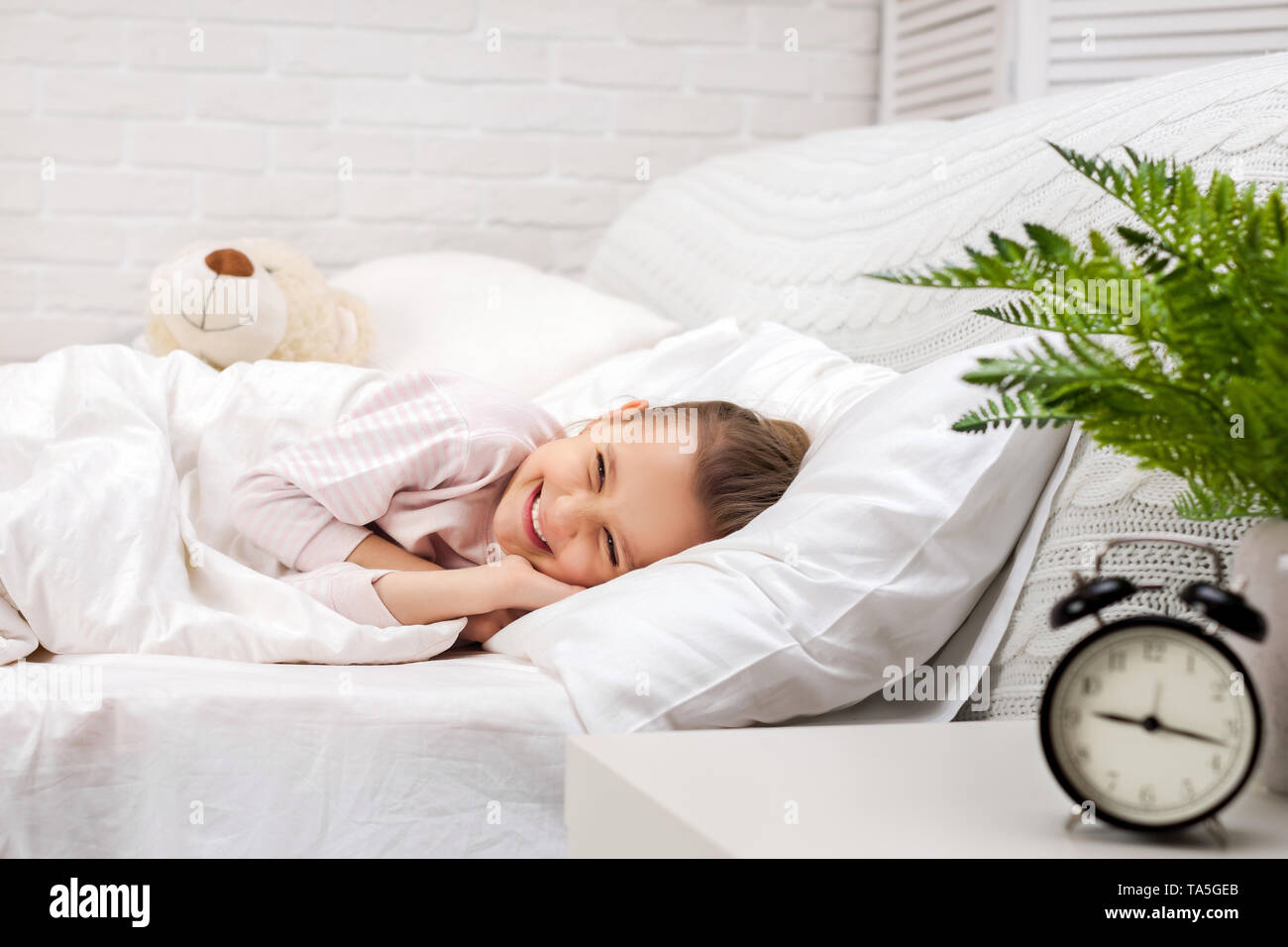 smiling little child girl sleeping with teddy bear in her bed Stock ...