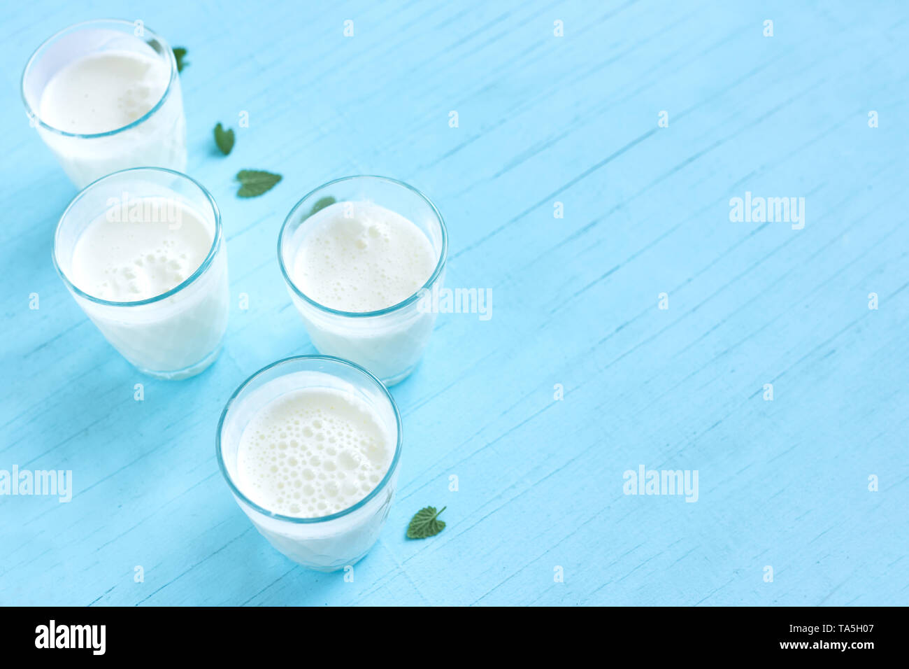 Ayran, homemade yogurt drink (kefir, lassi) with cucumbers - healthy summer refreshing cold drink on blue, copy space. Stock Photo