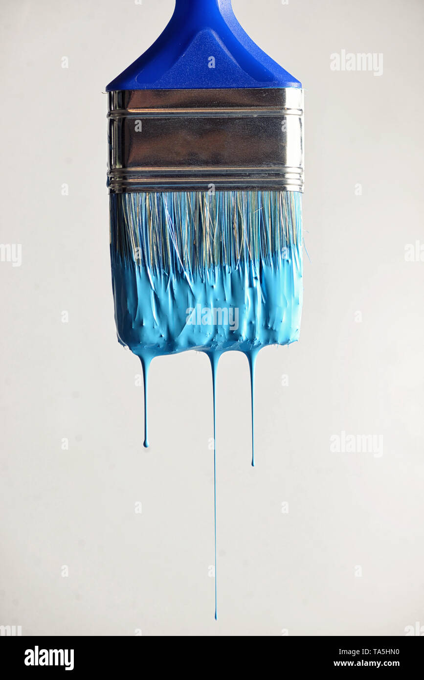 Dripping blue water paint from brush Stock Photo