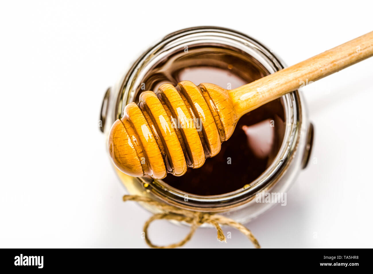 Honey dipper and glass jar of honey, top view Stock Photo - Alamy