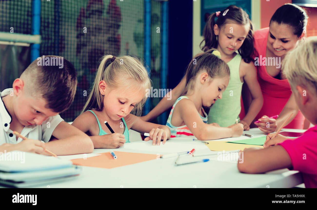 Happy children drawing on lesson in elementary education class with ...