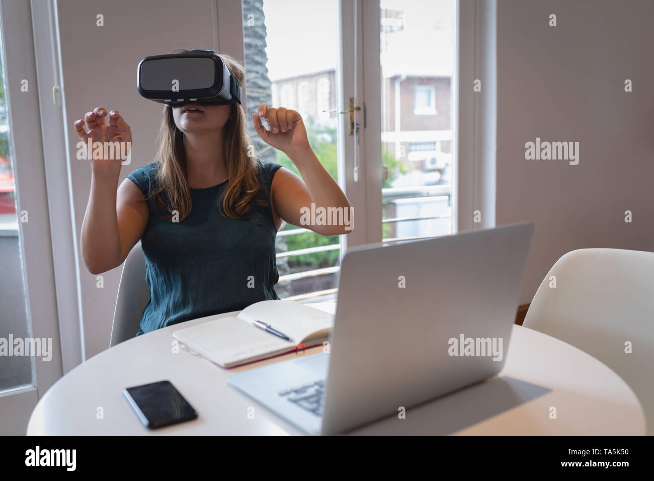 Women using virtual reality headset at a table Stock Photo