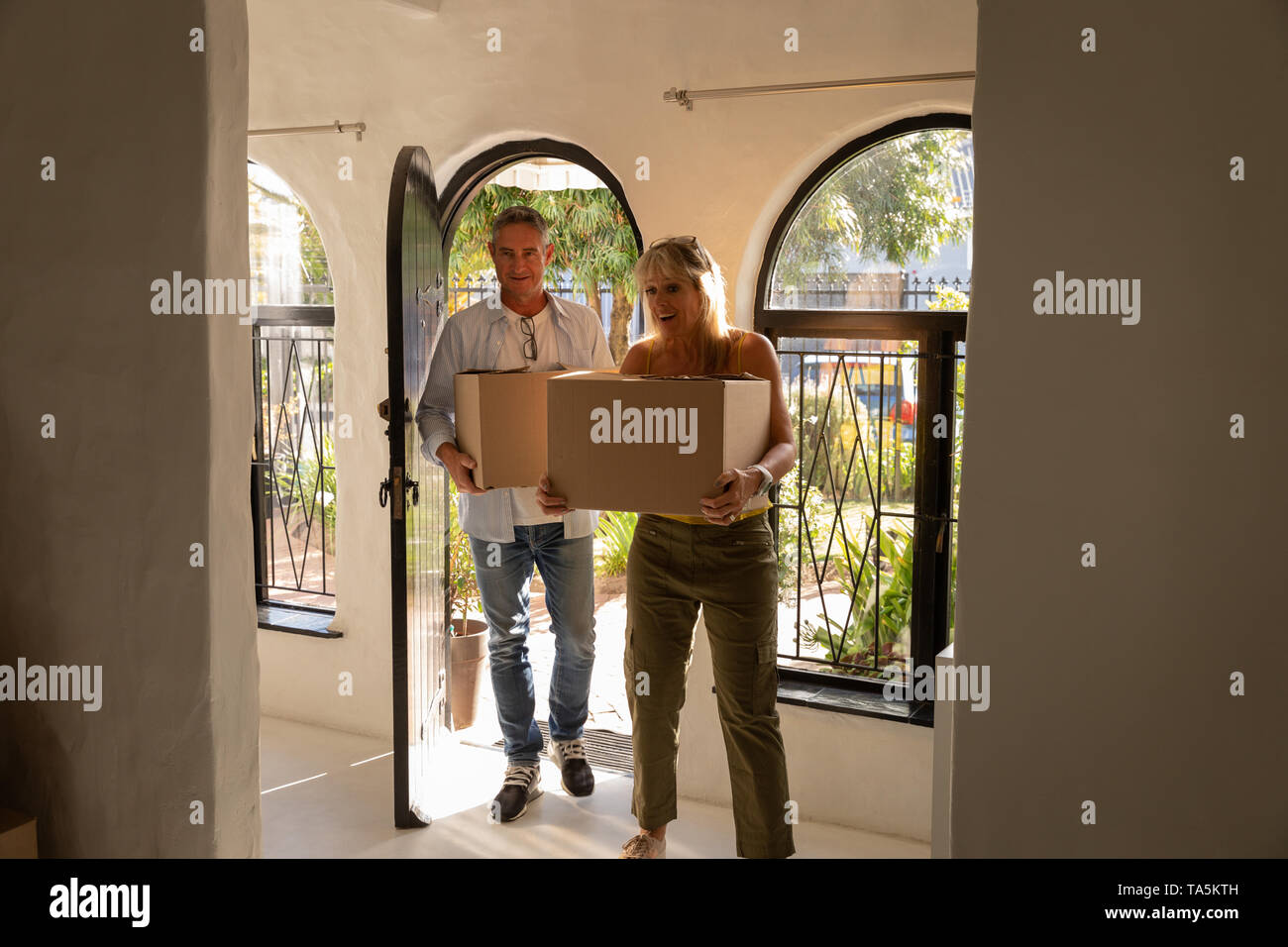 Mature couple with moving cardboard boxes in new home Stock Photo - Alamy