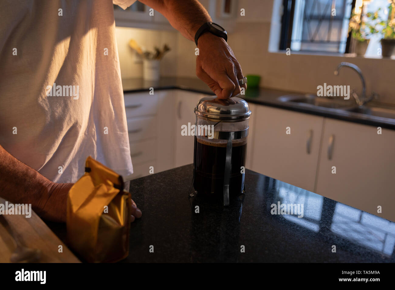 Mature man preparing coffee in kitchen at home Stock Photo