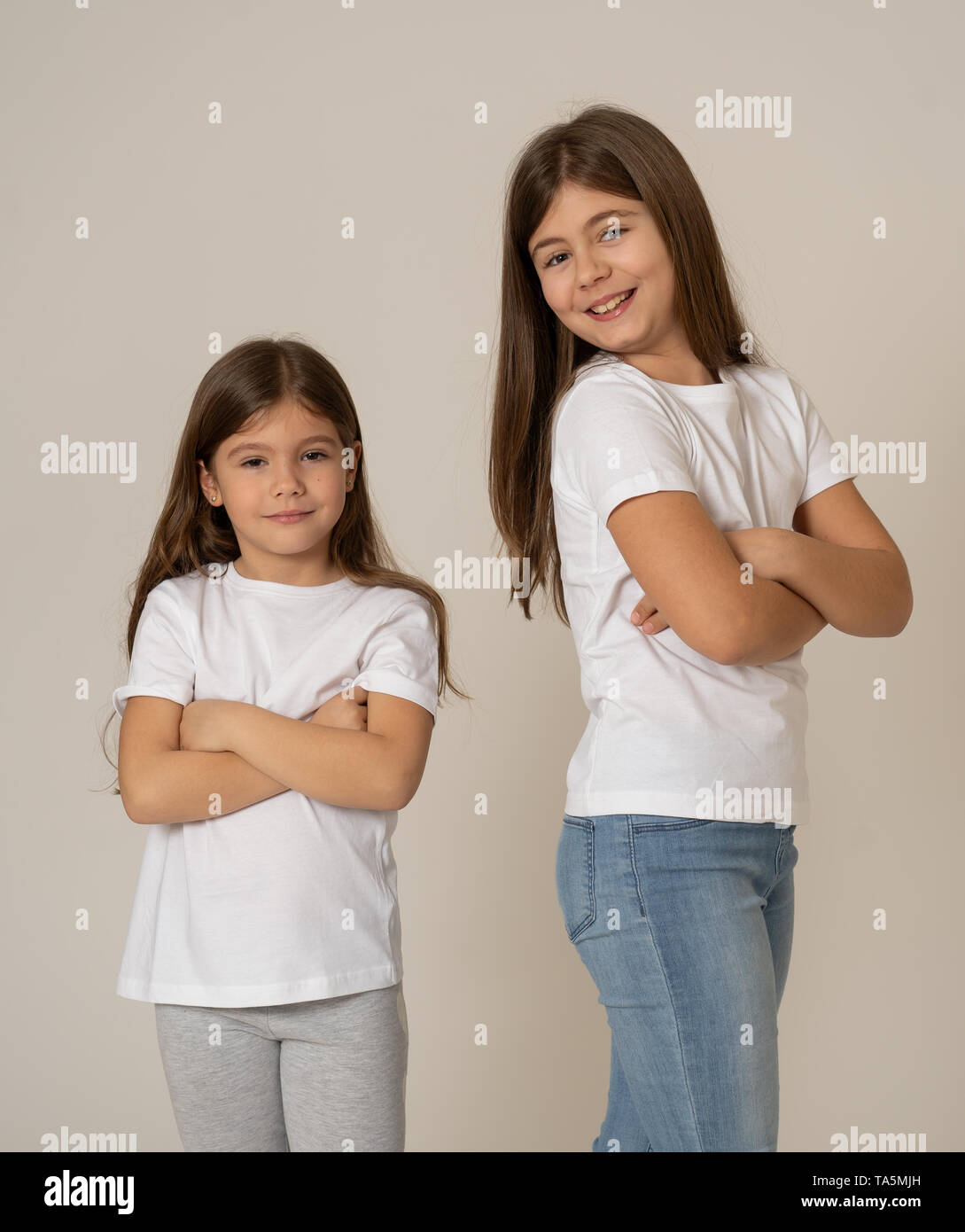 Cute portrait of two cheerful siblings girls sisters having fun together  hugging and laughing posing for the camera. Studio shot with copy space. In  F Stock Photo - Alamy