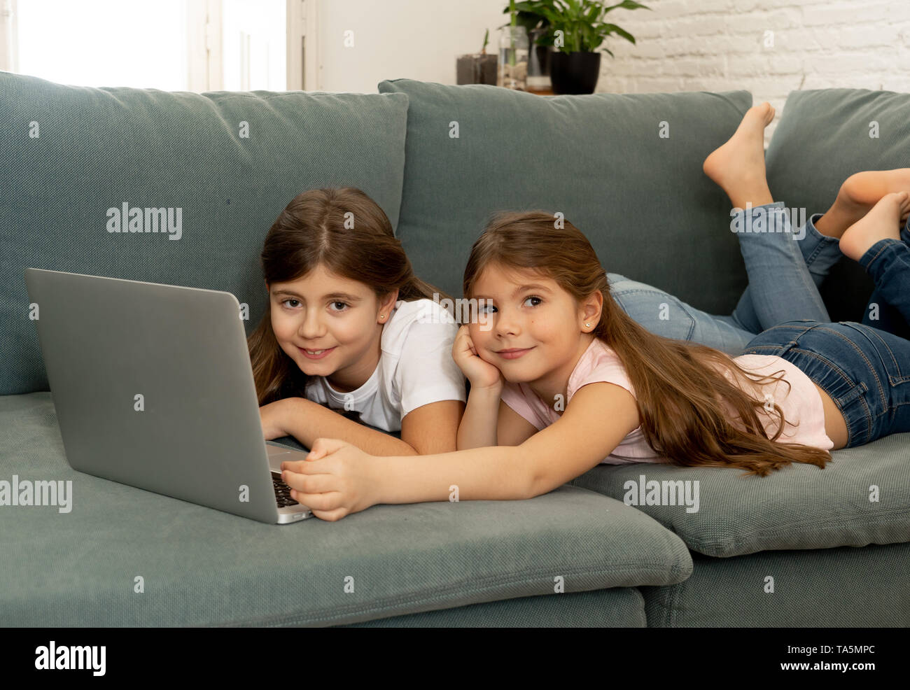 Cute little girl and older sister playing together smiling and having ...