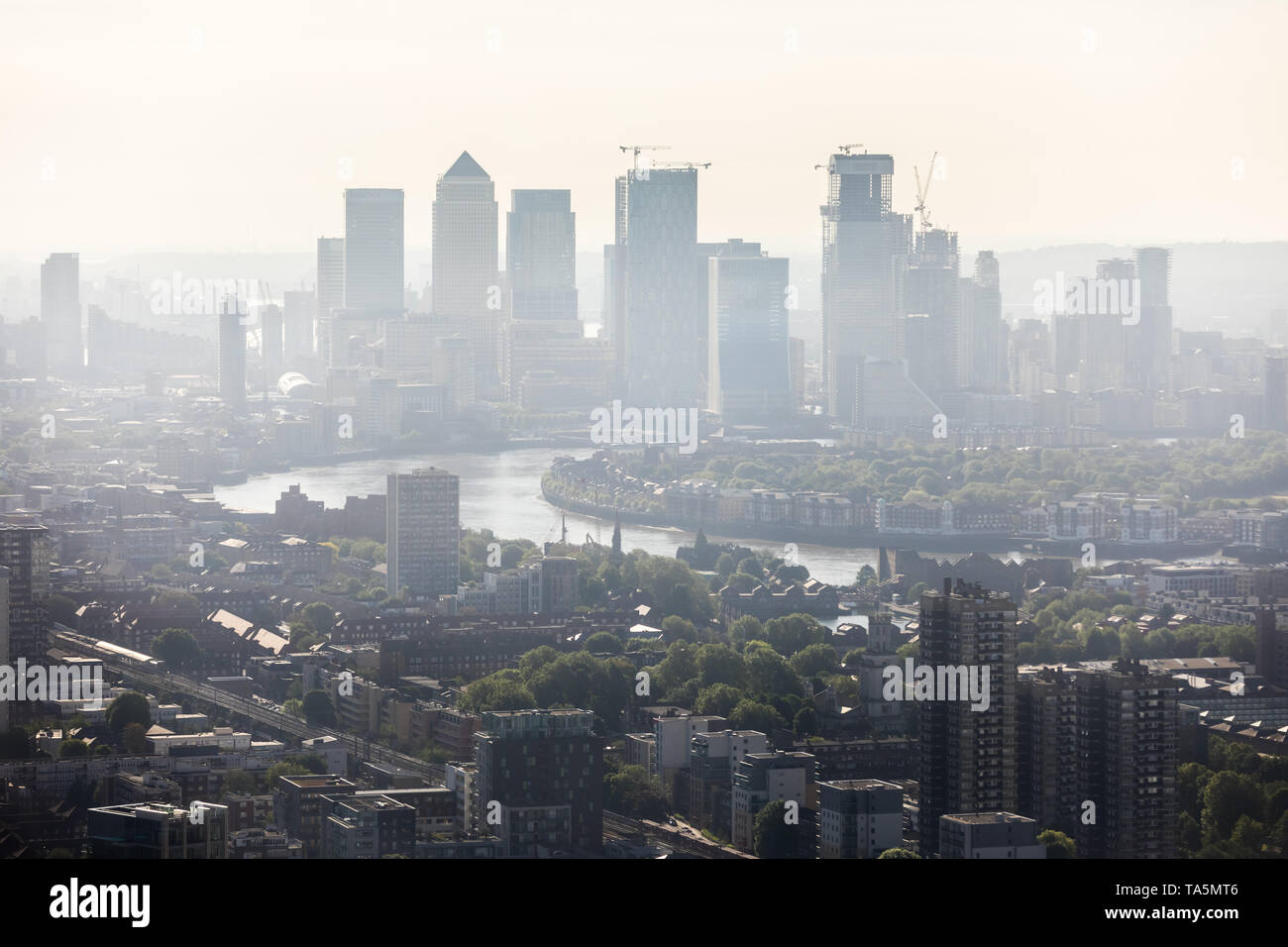 UK Weather: Morning city haze over Canary Wharf business park buildings in east London. Local air particulate pollutant emissions currently 'moderate' Stock Photo