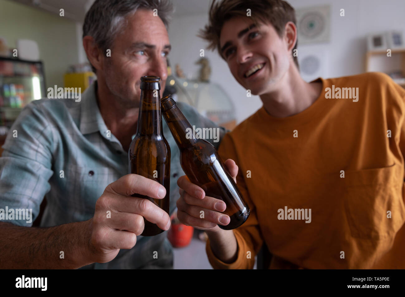 Father and son toasting beer bottle Stock Photo