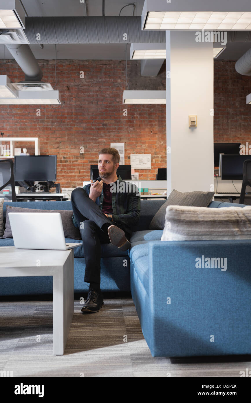 Businessman sitting on sofa in the office Stock Photo