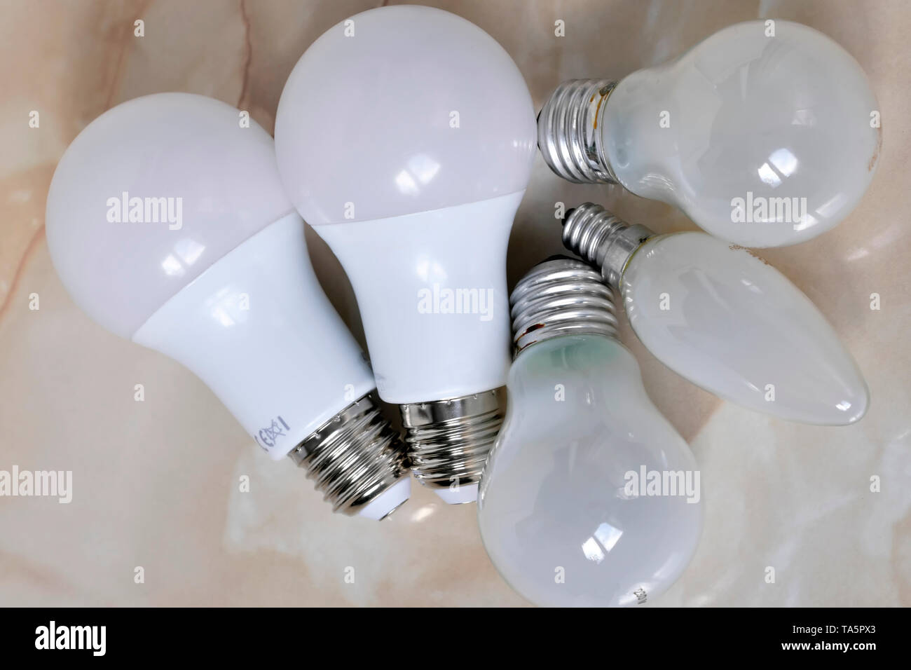 Lighting electric lamps for living rooms LED and incandescent bulbs close-up lie on the table Stock Photo
