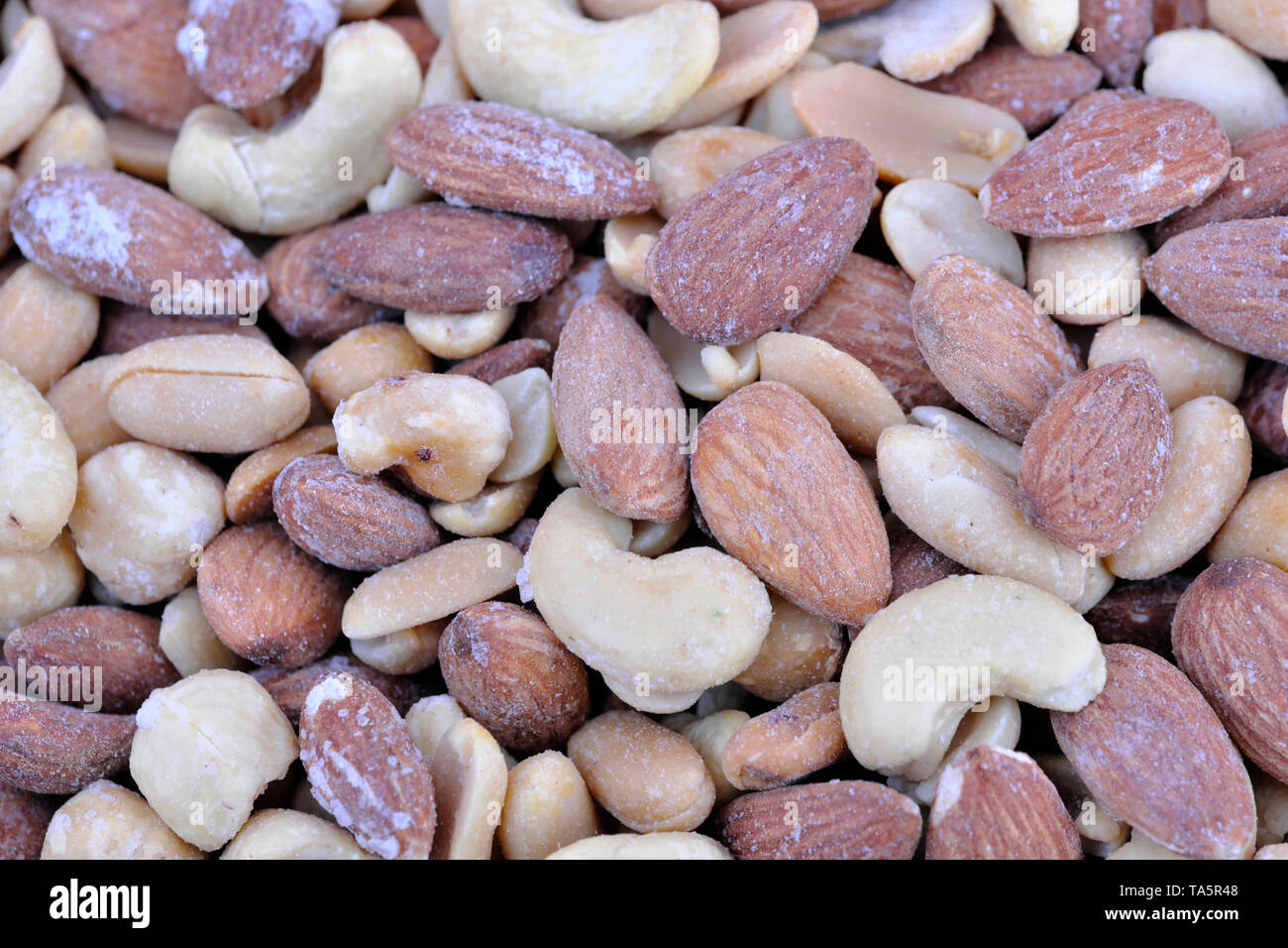 Roasted almond and cashew kernels coated with various ingredients in close-up, macro Stock Photo