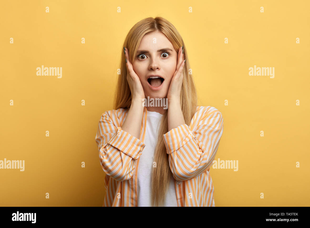 emotional beautiful fair-haired woman screaming with shock,, holding ...