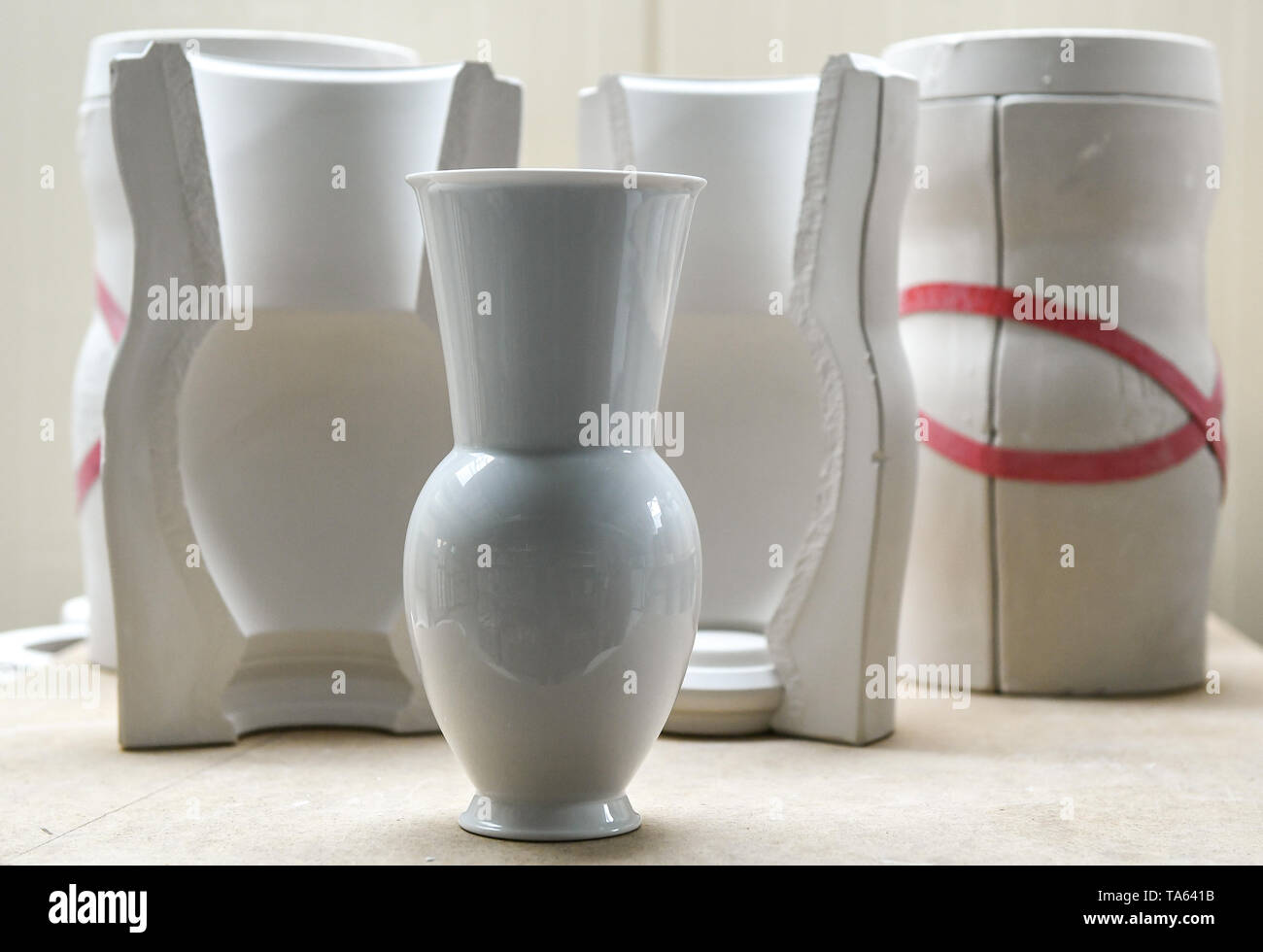 Berlin, Germany. 09th May, 2019. In the workshops of the Royal Porcelain  Manufactory KPM, a vase from the "Halle" series stands in front of moulds  that are used to cast these vases.