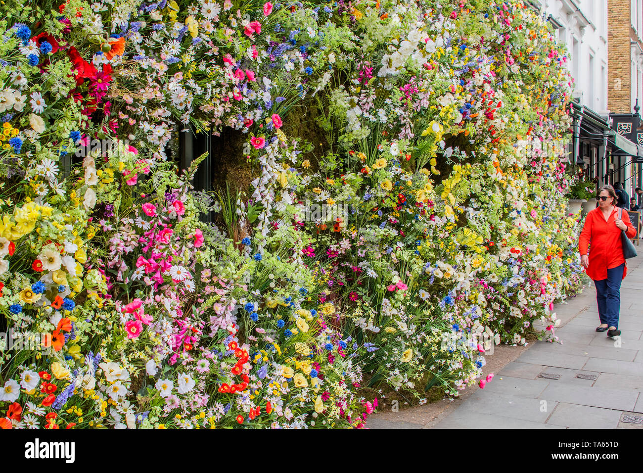 London, UK. 22nd May 2019. People pass by but many are drawn to stop an take pictures or selfies at The Ivy Chelsea Garden Branch - Chelsea in Bloom, part of the finge activities to the Chelsea Flower Show. Credit: Guy Bell/Alamy Live News Stock Photo