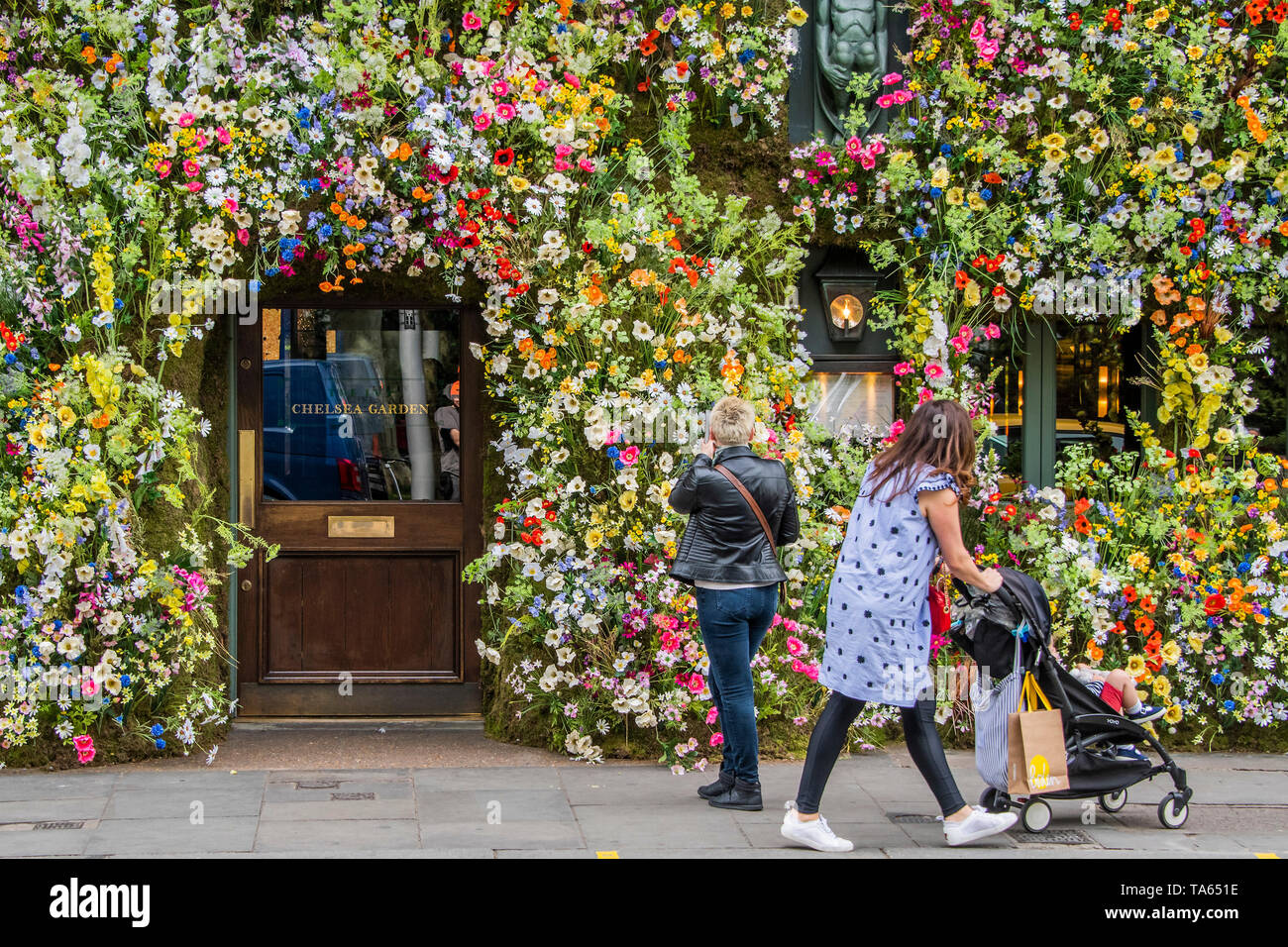 London, UK. 22nd May 2019. People pass by but many are drawn to stop an take pictures or selfies at The Ivy Chelsea Garden Branch - Chelsea in Bloom, part of the finge activities to the Chelsea Flower Show. Credit: Guy Bell/Alamy Live News Stock Photo