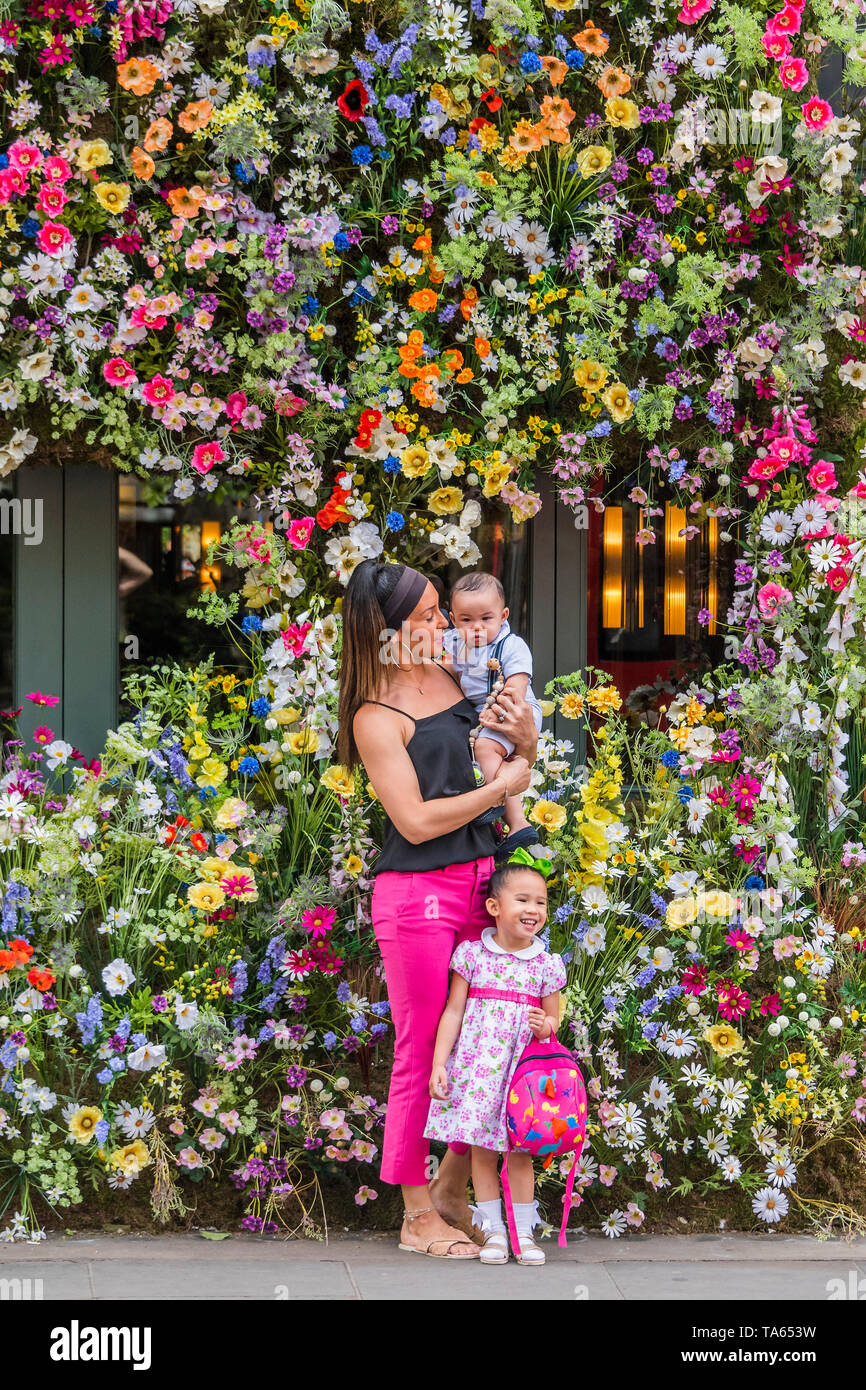 London, UK. 22nd May 2019. People pass by but many are drawn to stop an take pictures or selfies at The Ivy Chelsea Garden Branch - Chelsea in Bloom, part of the finge activities to the Chelsea Flower Show. Credit: Guy Bell/Alamy Live News Stock Photo