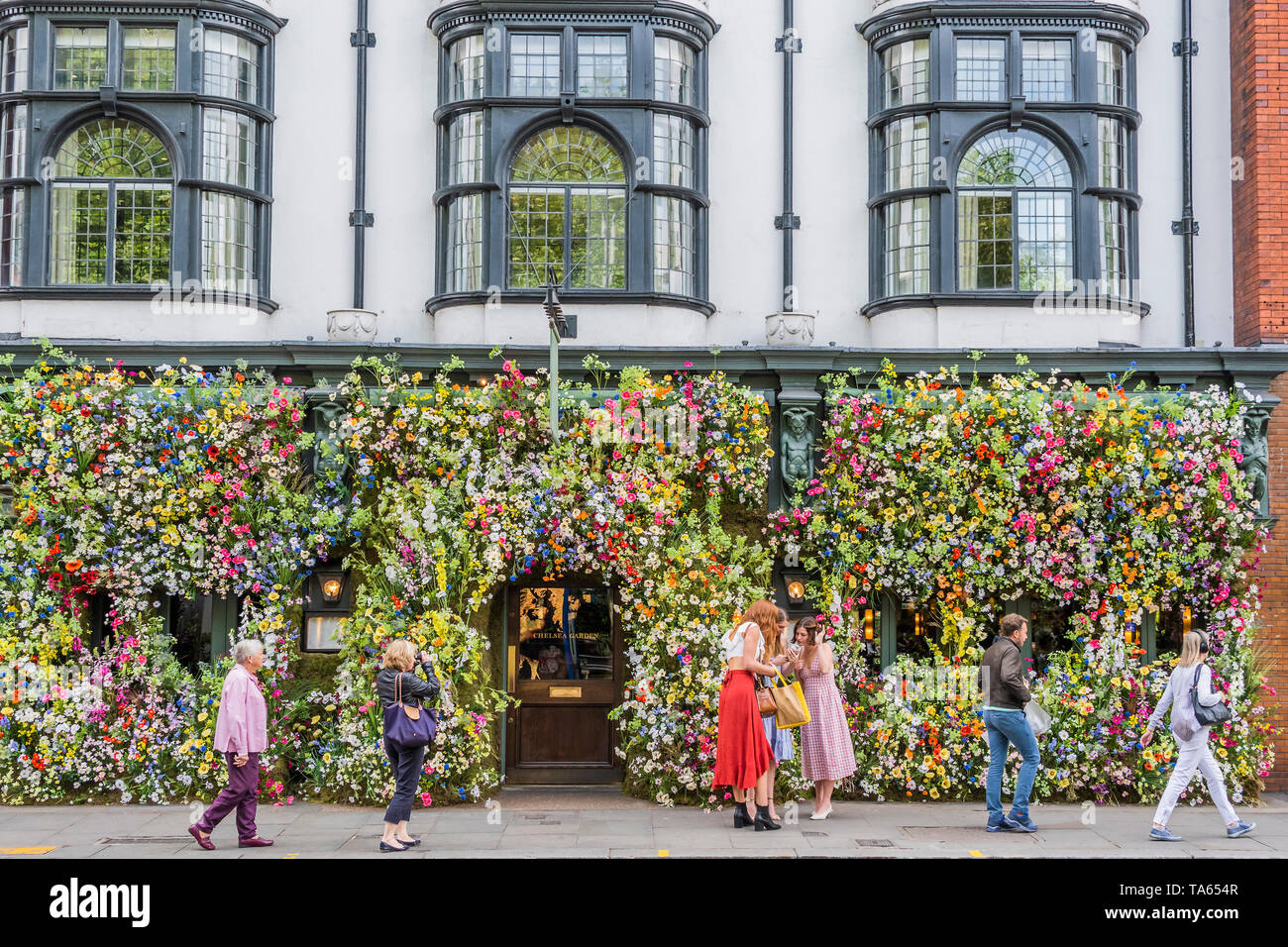 London, UK. 22nd May 2019. People pass by but many are drawn to stop an take pictures or selfies at The Ivy Chelsea Garden Branch - Chelsea in Bloom, part of the finge activities to the Chelsea Flower Show. Credit: Guy Bell/Alamy Live News Stock Photo