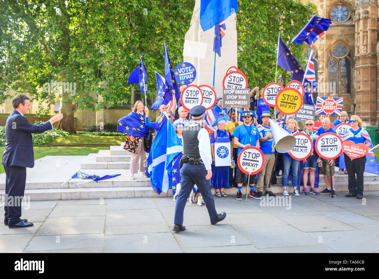 Westminster, London, UK, 22nd May 2019. A policeman interrupts the protest to remind demonstrators not to use the word 'Bollox' when shouting. Anti Brexit protesters outside Parliament get together for a 'Stop Brexit' shout out with placards, banners and Stop Brexit signs. Protesters have come from different groups, including Steve Bray, founder of SODEM (Stand of Defiance European Movement), knwon as Westminster's 'Mr. Shouty Man'. Credit: Imageplotter/Alamy Live News Stock Photo