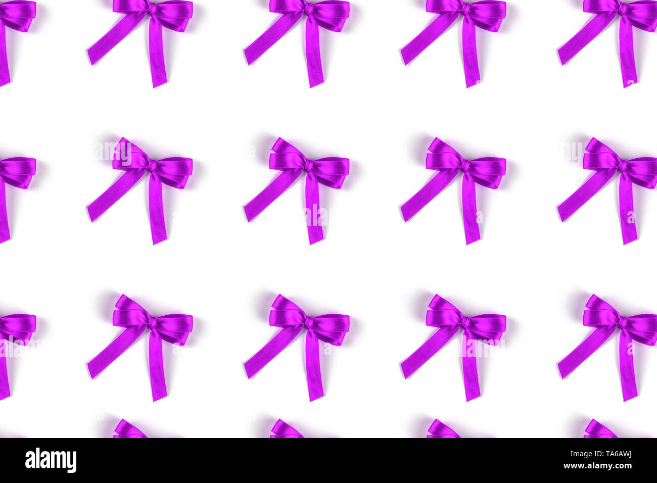 Pattern of violet silk gift bows isolated on white. Stock Photo