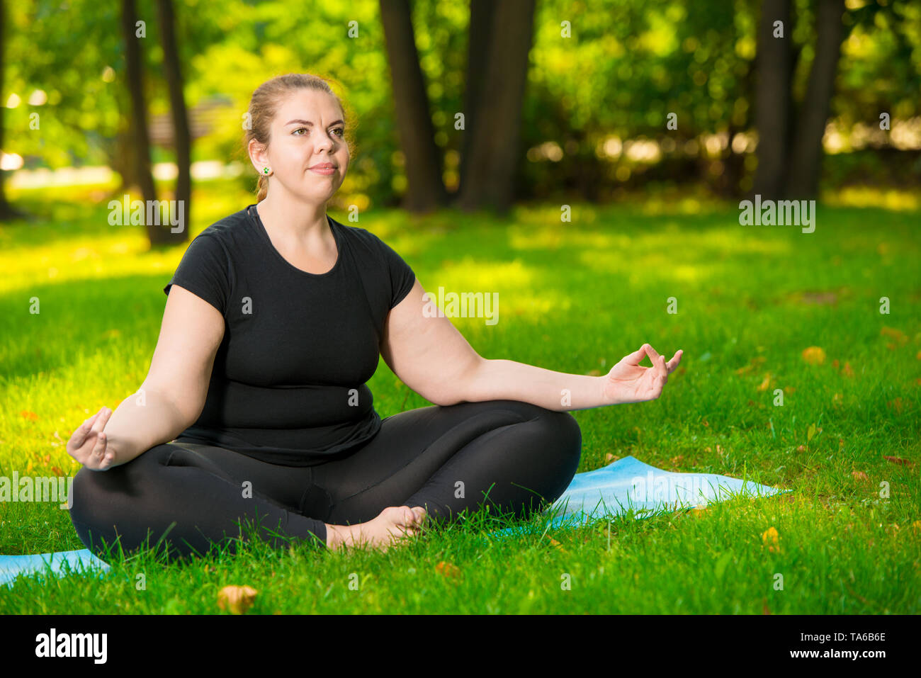 meditation in the park, a portrait of a focused model over size during a yoga workout Stock Photo